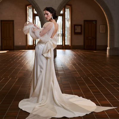 Model wearing Savannah wedding dress with sleeves and bow detail from the Royal collection