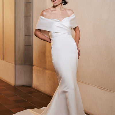 Model wearing fitted Serenity wedding dress with off shoulder sleeves from the Royal collection
