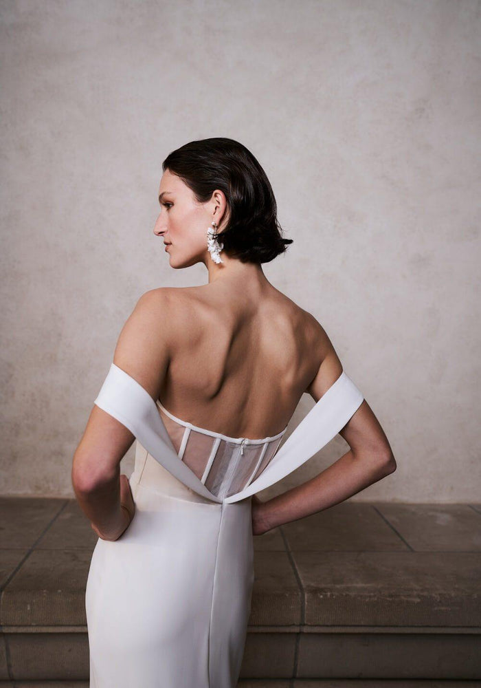 Off-the-shoulder, mesh open back mermaid silhouette wedding dress.