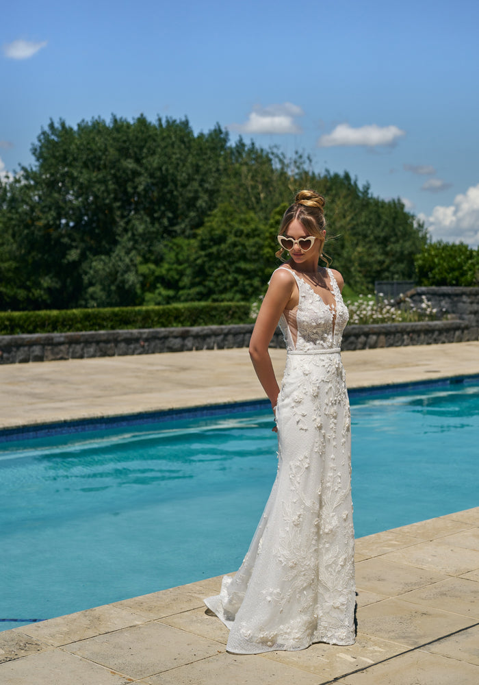 Fit-n-flare silhouette gown Taisha in ivory with 3D leafy applique. Plunging v-neckline with beaded waistbelt