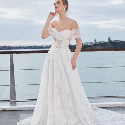 Teresa gown. Sheer floral organza fabric with sweetheart neckline that crosses over the bust and ruches at the side seams. Full A-line skirt with soft flowing train.