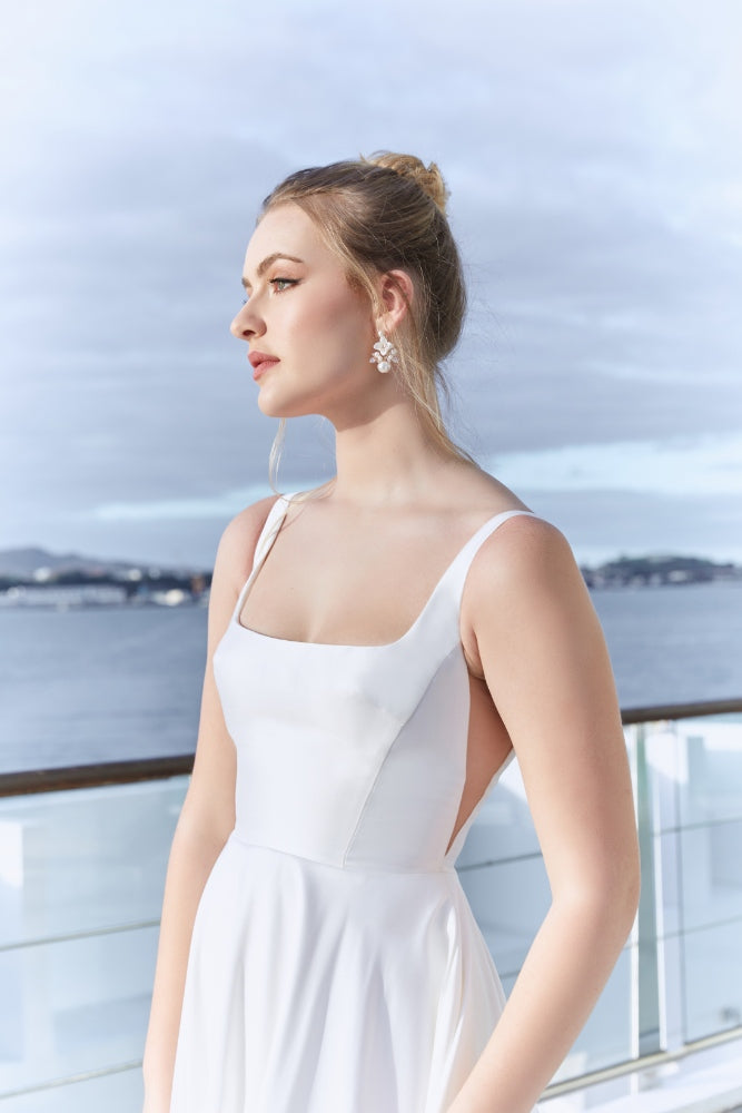 Side view of the bodice of Trinity gown. Uniquely shaped bust darts and illusion mesh paneling at the sides create sleek lines on this square neck gown.