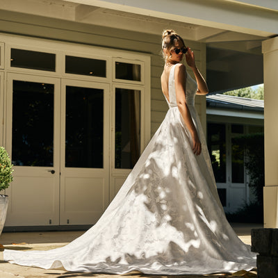 Back view of Pari gown. Classic cut with plunging v back. A-line skirt from waist with dramatic train.