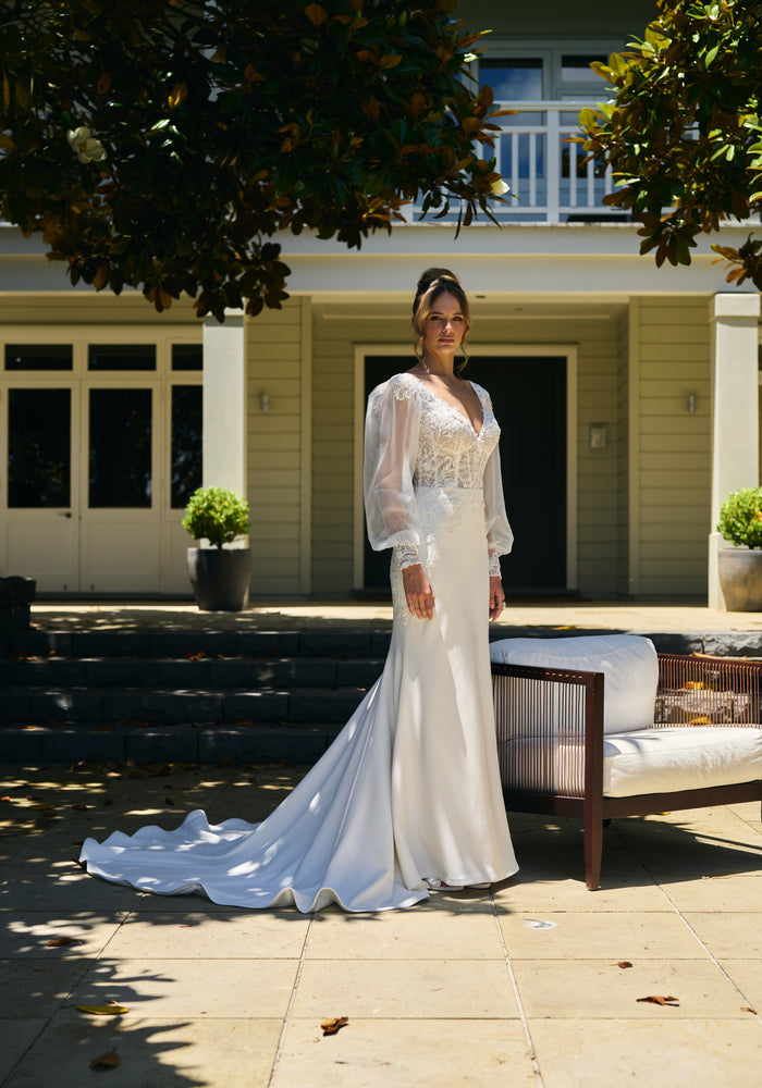 Bride wears primrose gown. Fit-n-flare silhouette with organza balloon sleeves and a lace boned bodice with v-neckline.